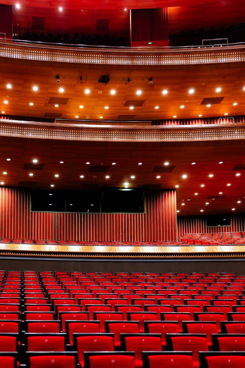 An empty auditorium with red seats and a stage
