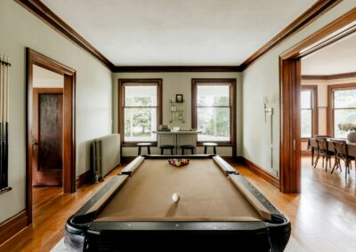 A pool table in a large room with wooden floors